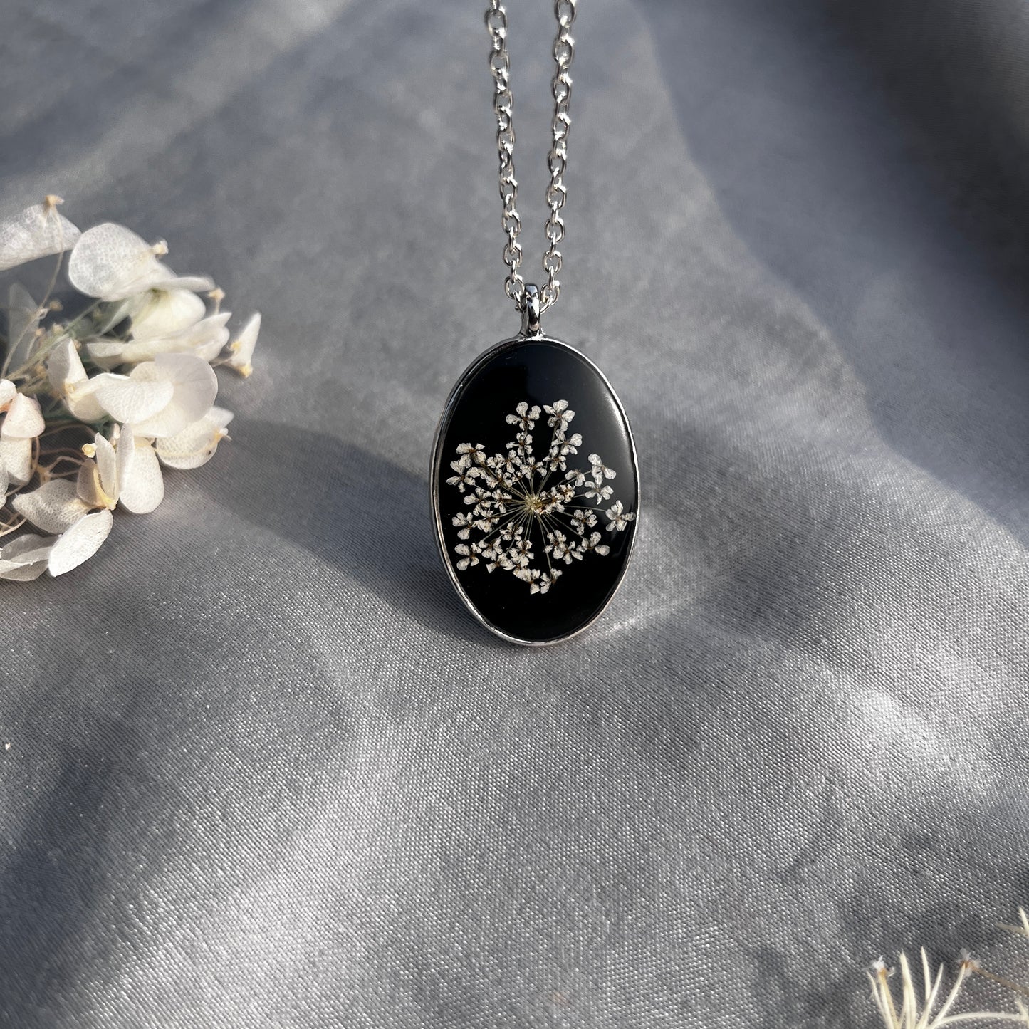 Black Oval Resin Pendant with Real White Flower โ Silver Chain Botanical Jewel